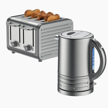 Grey Dualit toaster with bread slices and a matching silver kettle on a white background